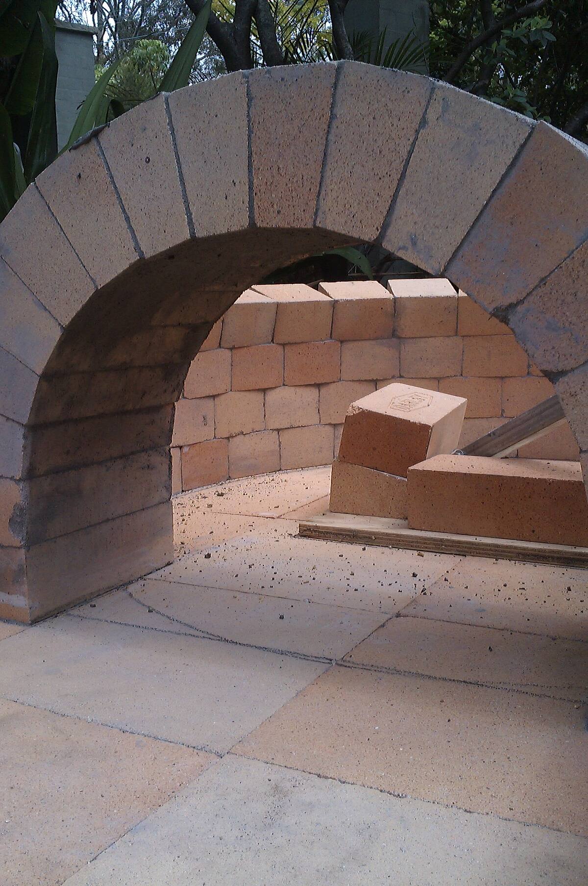 Firebrick arch and dome under construction for a wood-fired oven