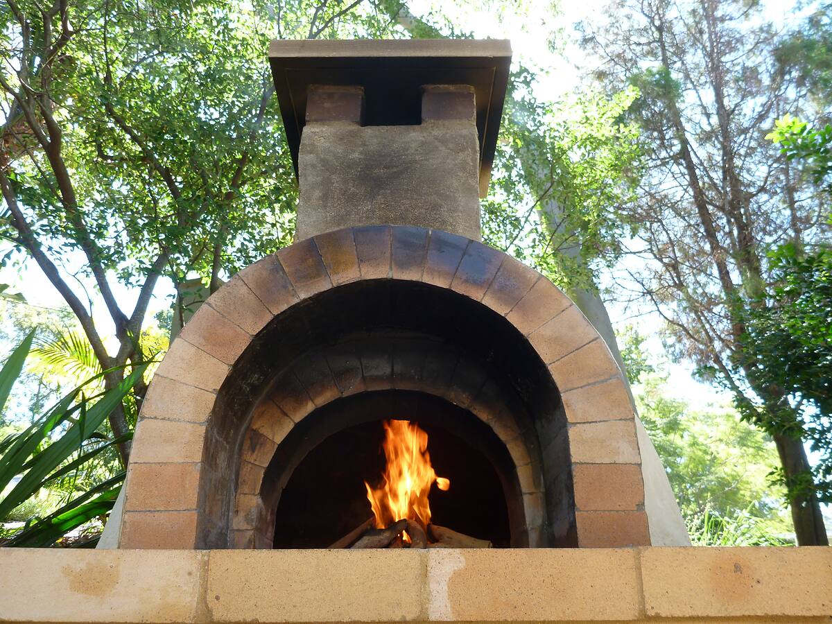 Authentic brick pizza oven with chimney and a fire burning, Bayview