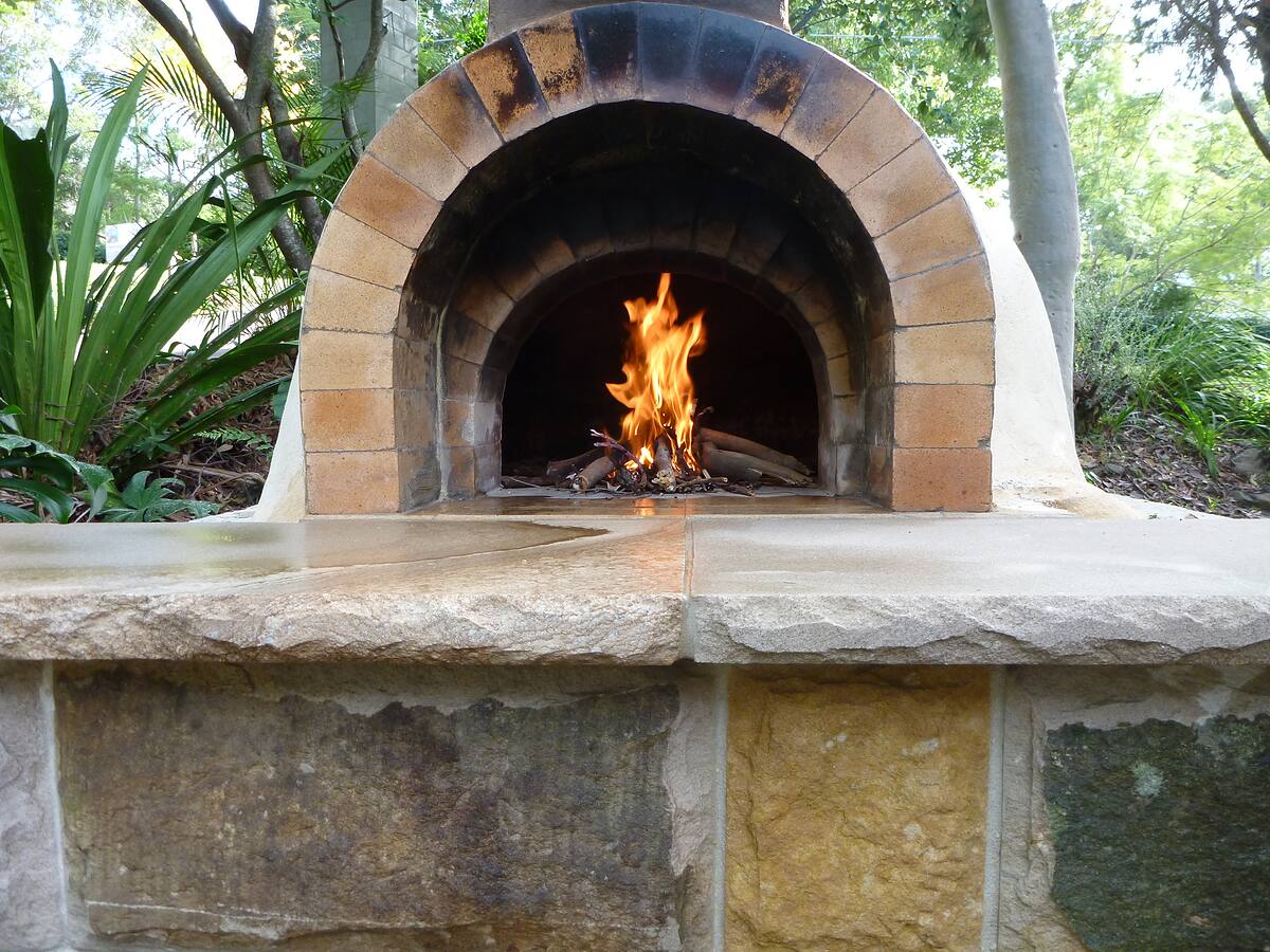 Firebrick dome wood-fired pizza oven on a sandstone base in Bayview