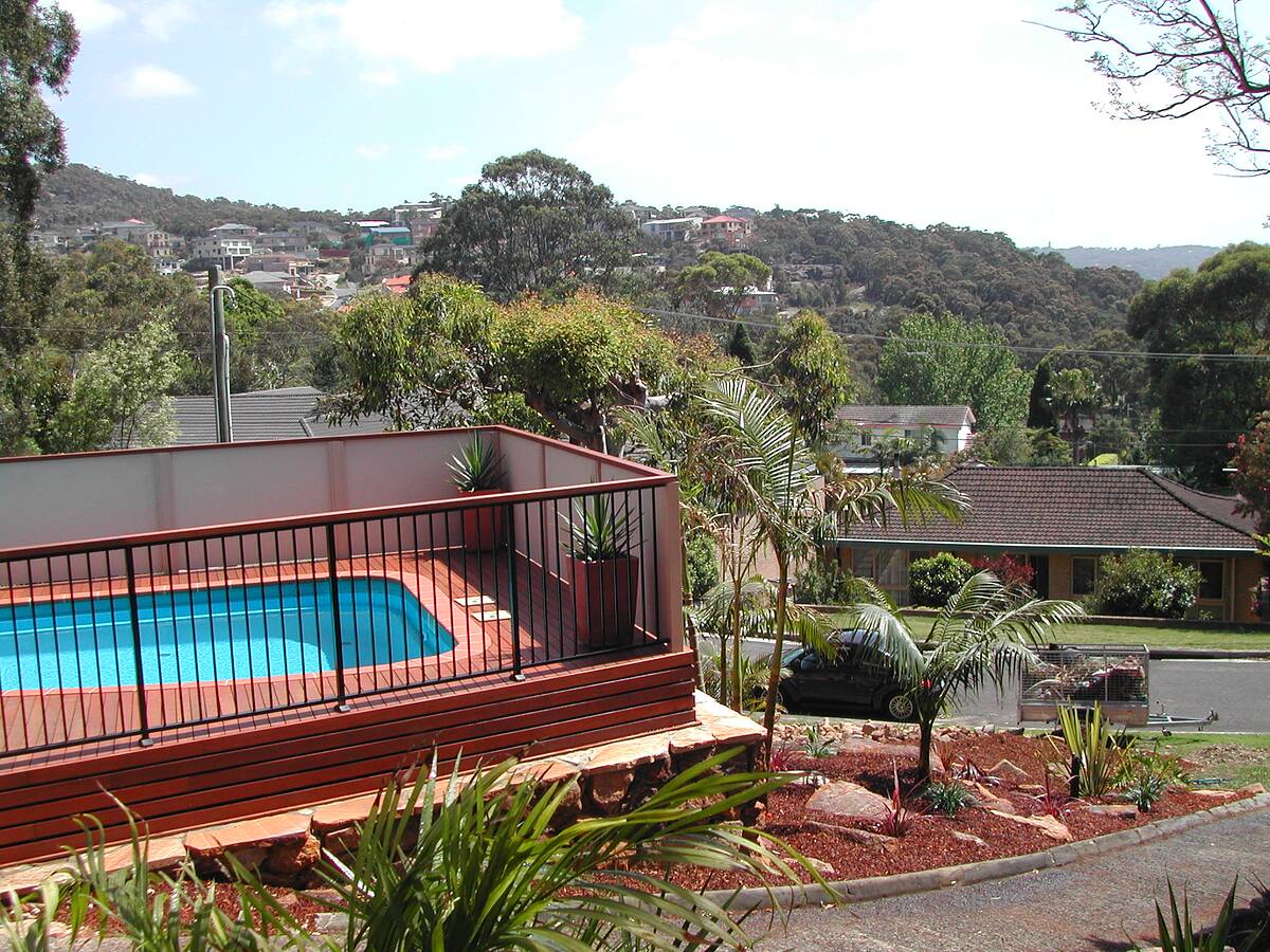 Sandstone-faced pool wall with glass fencing and garden, Cromer