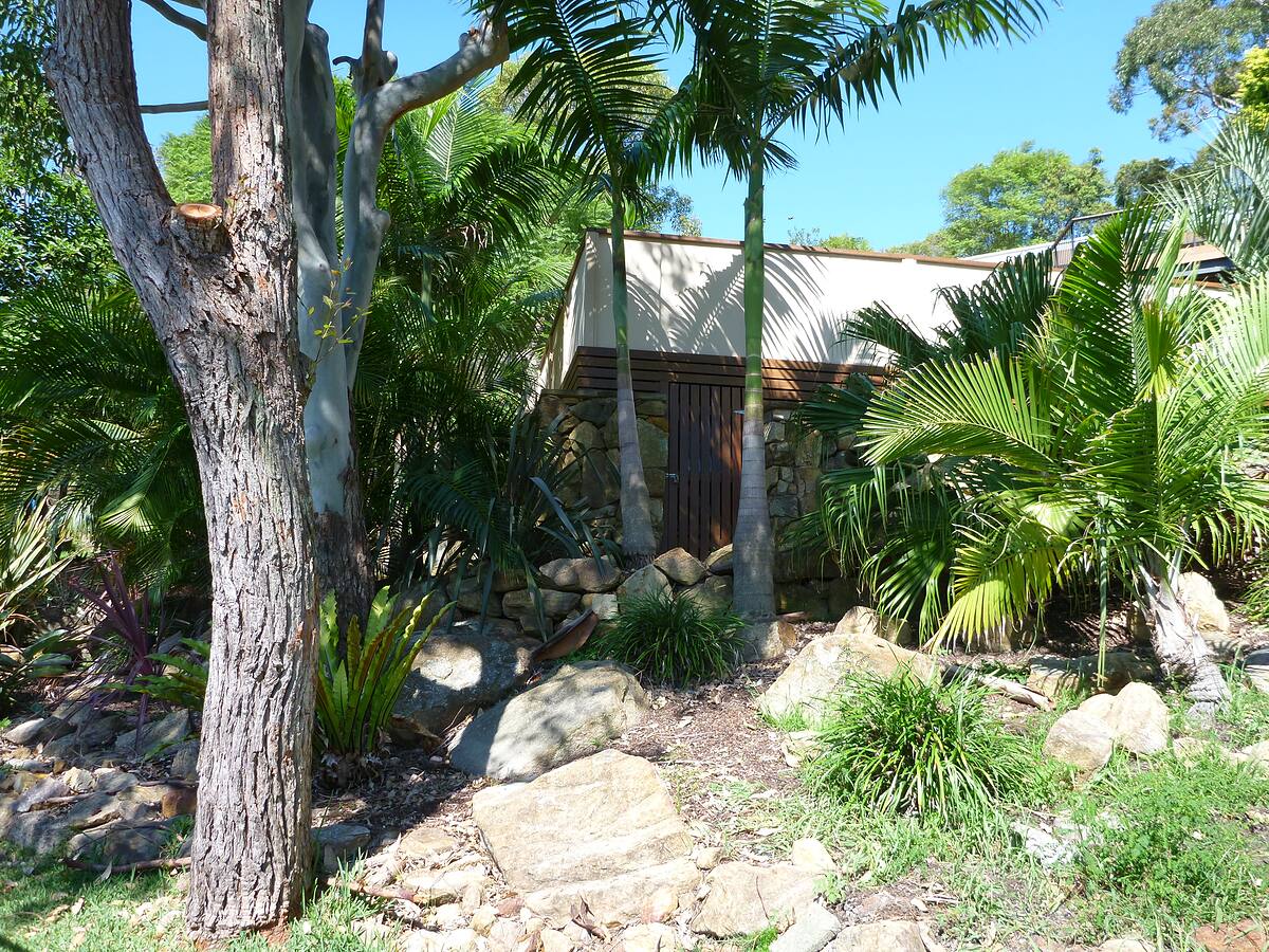 Tropical garden with palms and sandstone rocks