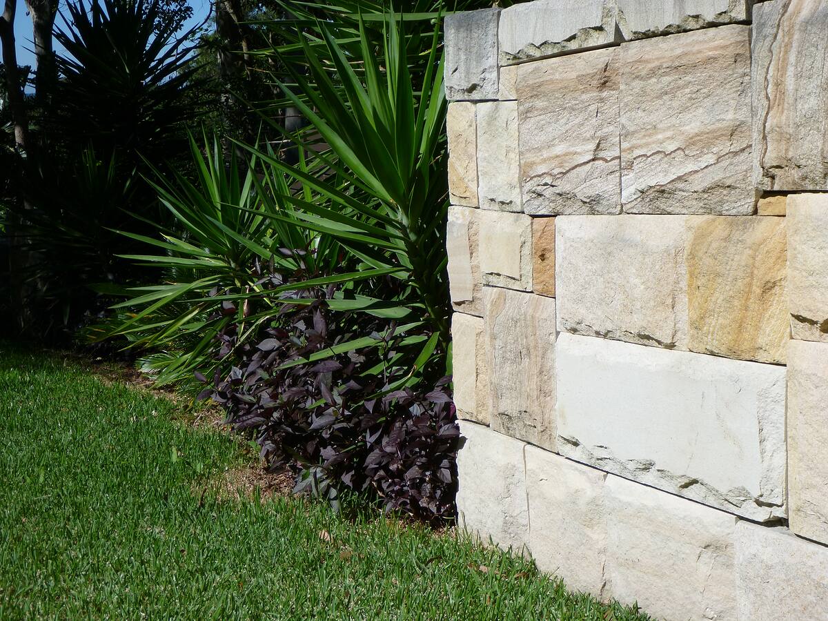 Dressed sandstone garden wall beside a lawn