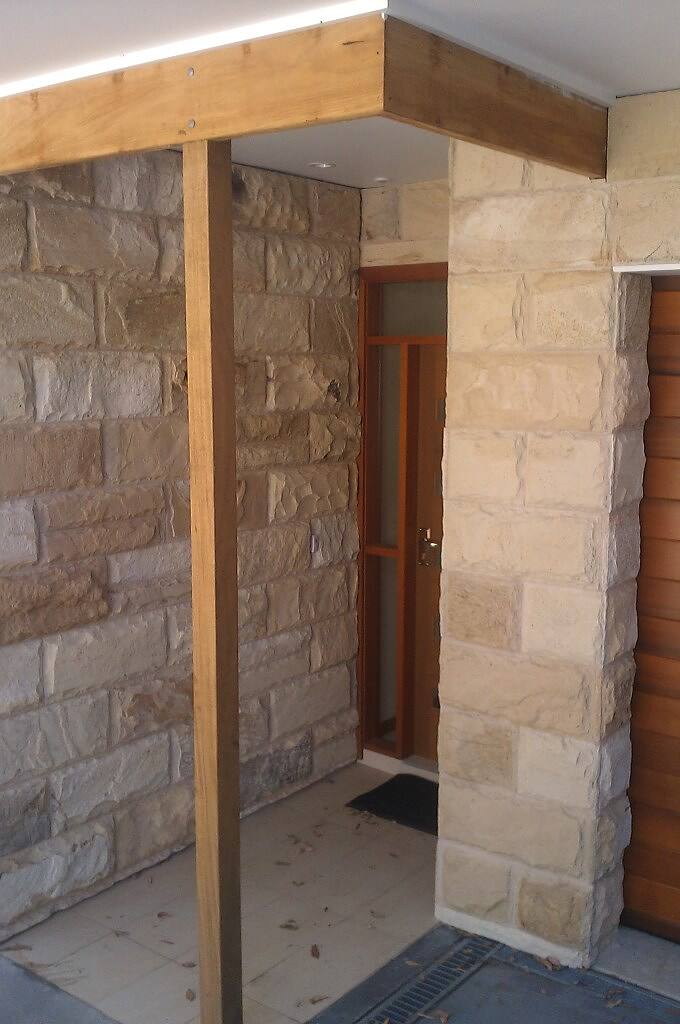 Sandstone-clad entry column beside a timber door