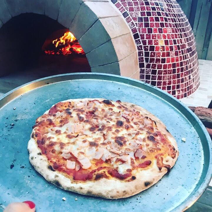 Pizza fresh from a mosaic-tiled wood-fired oven